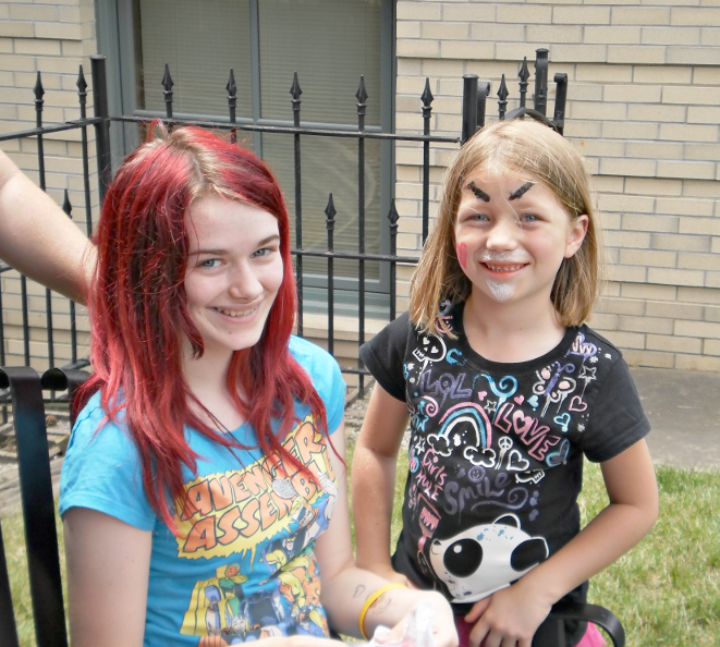 [photo of two girls, one with face paint and the other with dyed hair]