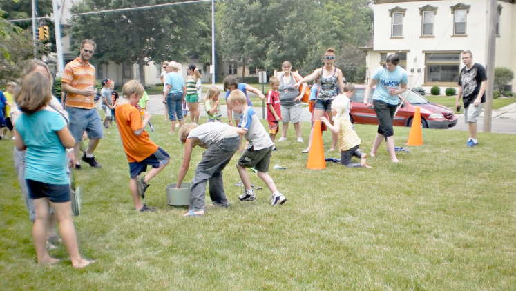 [photo of a large group of children playing games on the lawn]