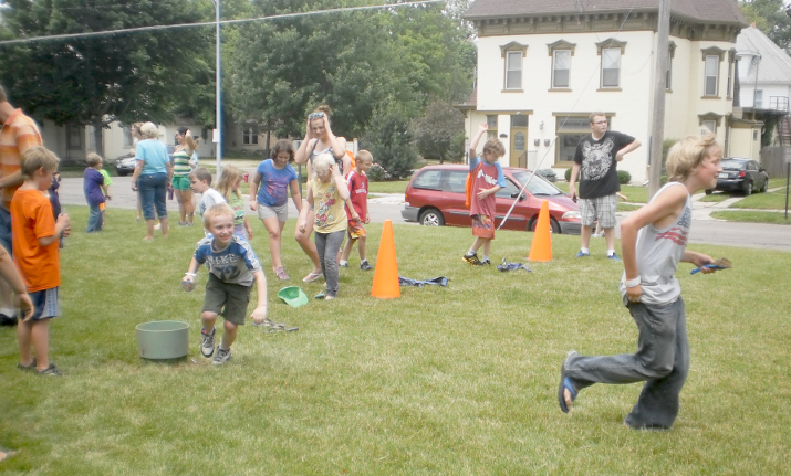 [photo of several children playing an active running game on the lawn]