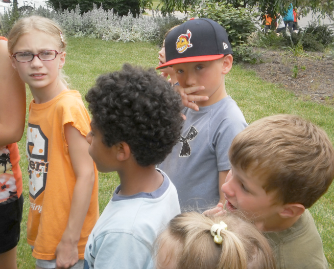 [photo of of several children standing in line]
